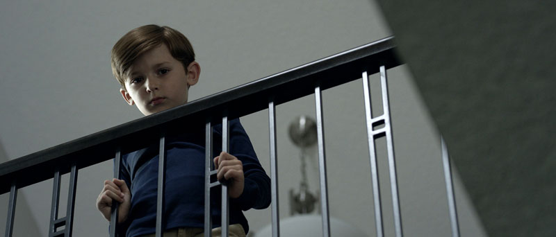 Nocturna 2019: un niño observa desde lo alto de la escalera de su casa.
