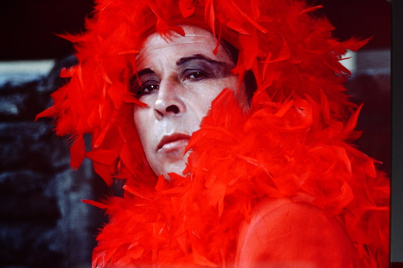Hombre maquillado vestido de rojo y peluca roja