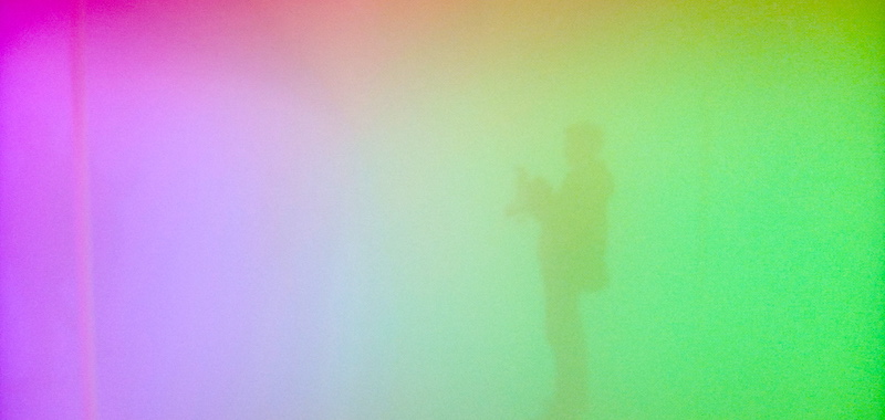 Olafur Eliasson - habitación con mucha niebla y llena de color rosa y amarillo y dos personas