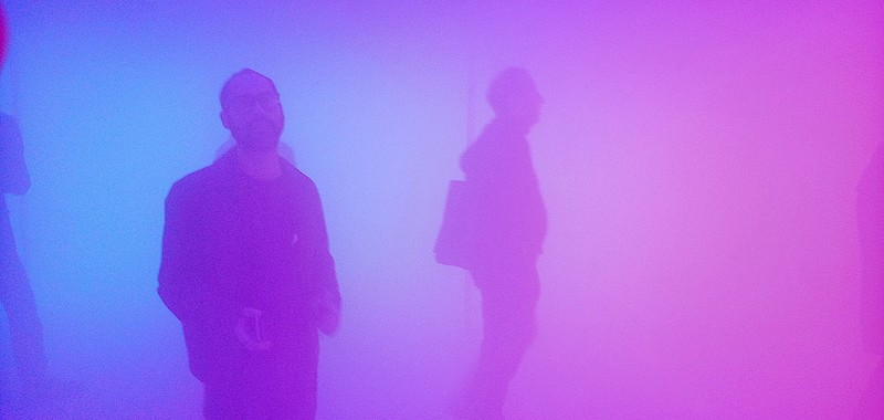 Olafur Eliasson - habitación con mucha niebla y llena de color rosa y dos personas