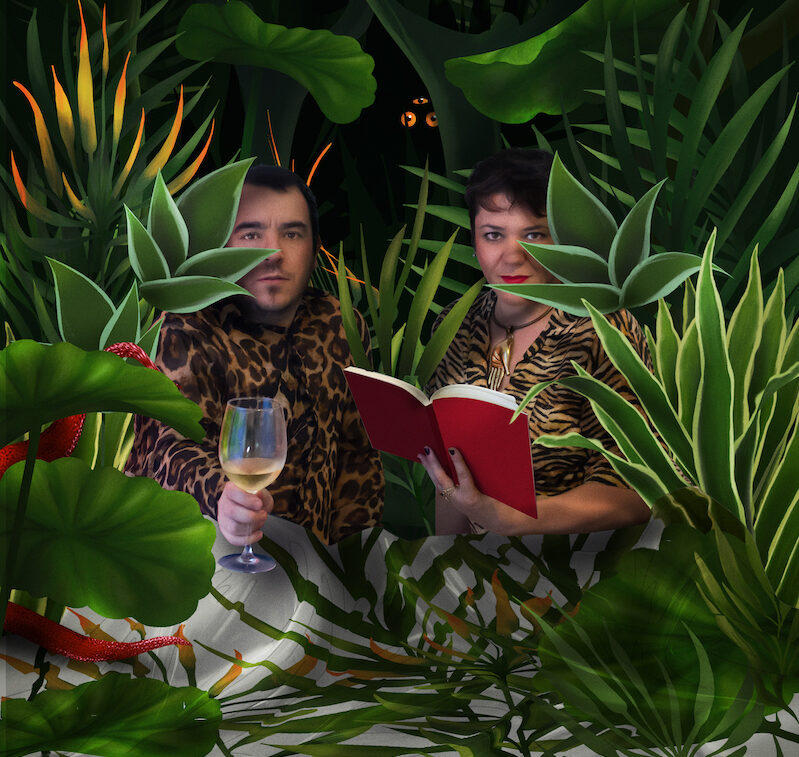 Post-Covid: retrato del artista Fito Conesa a la izquierda con una copa de vino y la comisaría Mery Cuesta con un libro, rodeados de plantas muy verdes tropicales