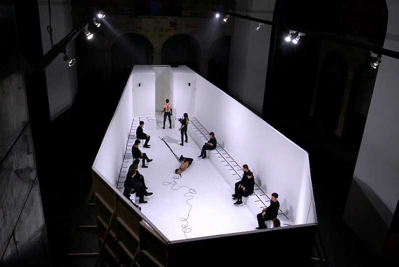 Joan Morey-expo COLAPSO-Fotograma del film perteneciente a la performance Potsmortem, vista cenizal de un espacio con diez personas dentro y con forma de ataúd