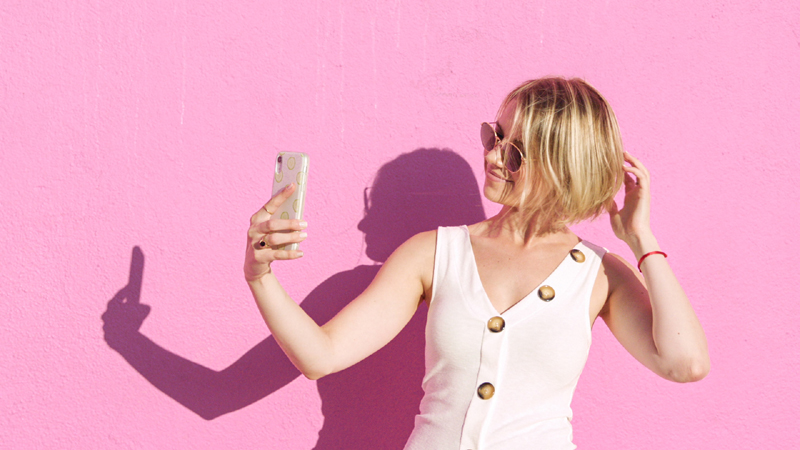 Fake famous: una chica haciéndose un selfie con el móvil.