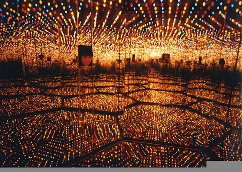 Yayoi Kusama, instalacion llena de luces redondas rodeada de espejos y hexágonos en el suelo