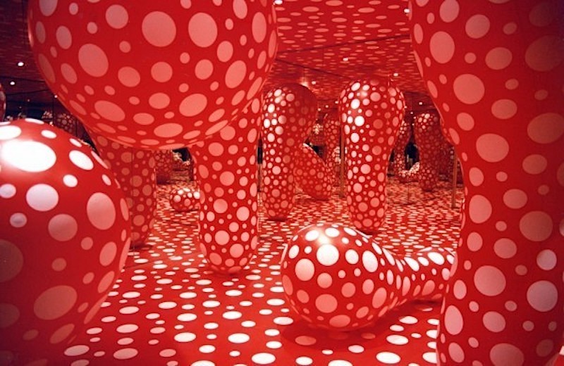 Yayoi Kusama instalación de una habitación llena de esculturas inflables de lunares blancos y rojos