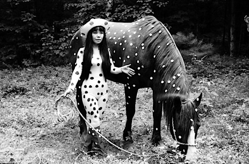 Yayoi Kusama, foto en blanco y negro de la artista con trajes de lunares y caballo al que le ha puesto lunares tambien.