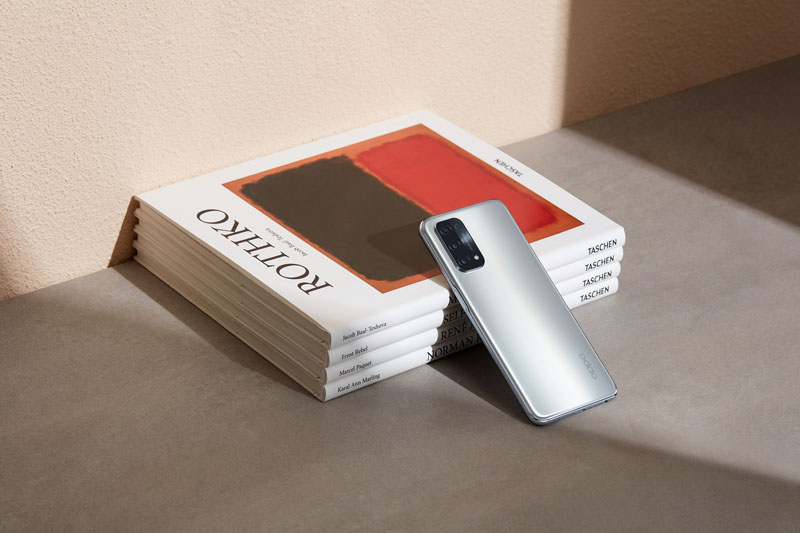 Oppo-Serie-A: A94, A74 y A54: un smartphone gris sobre un montón de revistas
