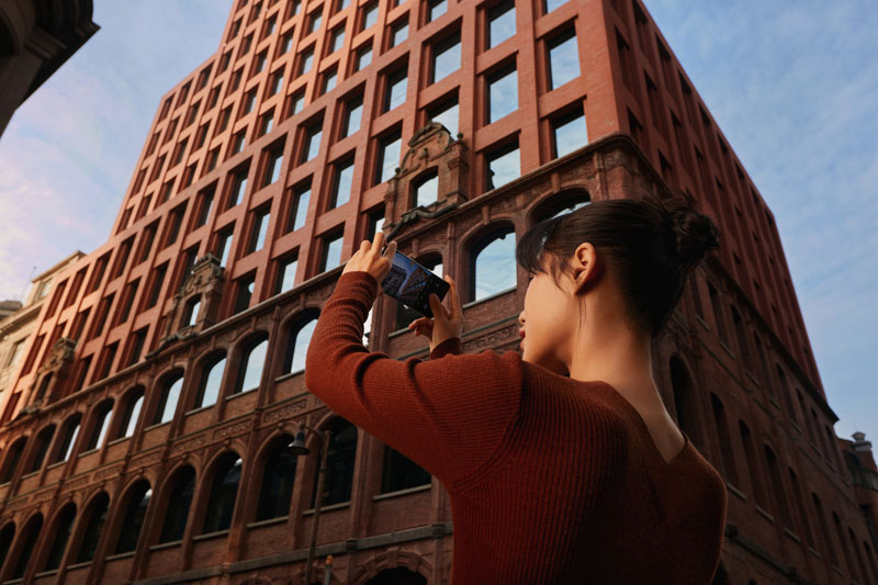 Oppo Find X3 Series: una chica fotografiando un edificio con el súper gran angular