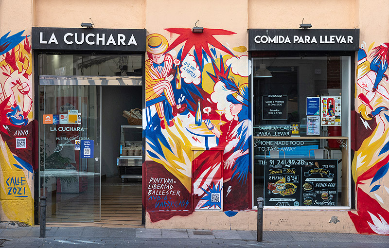 premio Alhambra CALLE 2021. Mural colorido en la fachada de un comercio de lavapíes