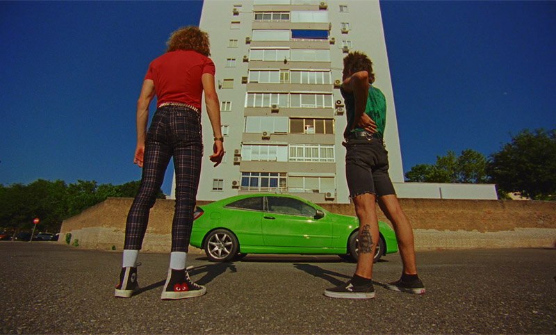 el amor amenazado - fotograma del corto, dos chicos miran un coche verde