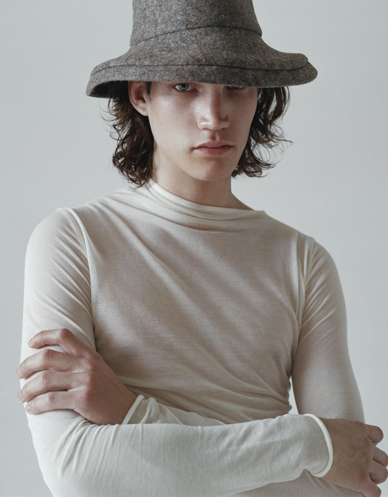 Editorial fotográfico mezcla moda y mobiliario: chico con gorro gris