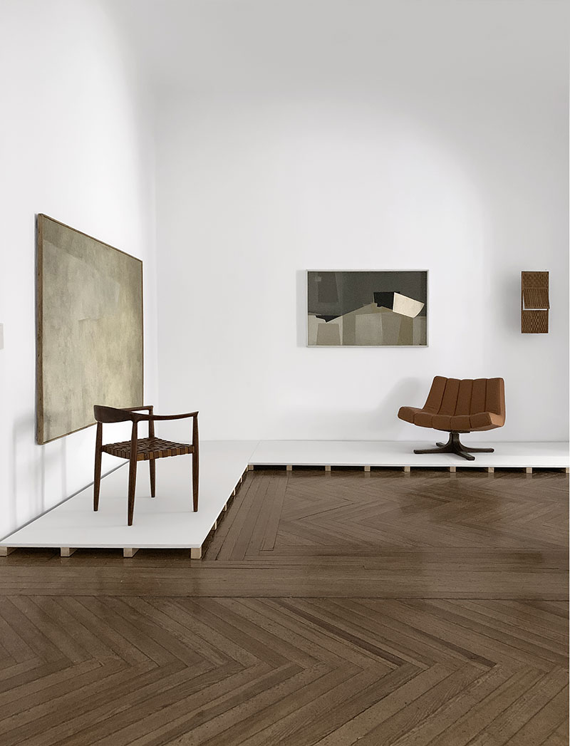 Galería José de la Mano: varios cuadros y un par de silla en la exposición