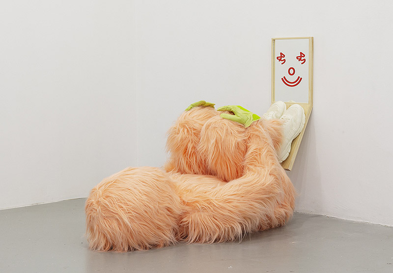Grip Face - SC gallery - escultura humanoide tumbada en el suelo forrada de peluche naranja