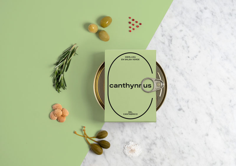 Canthynnus conservas gourmet: una lata redonda de merluza con los ingredientes a modo de concepto