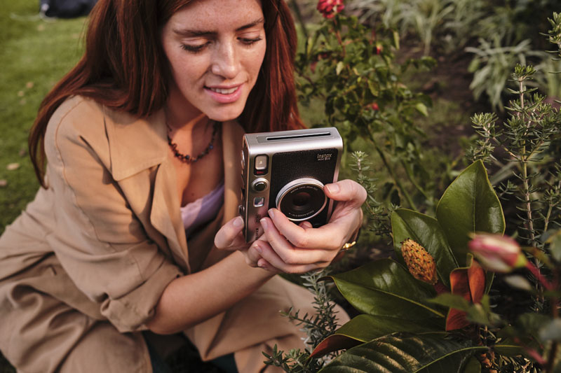 Instax Mini Evo Hybrid: una mujer haciendo una foto de unas flores