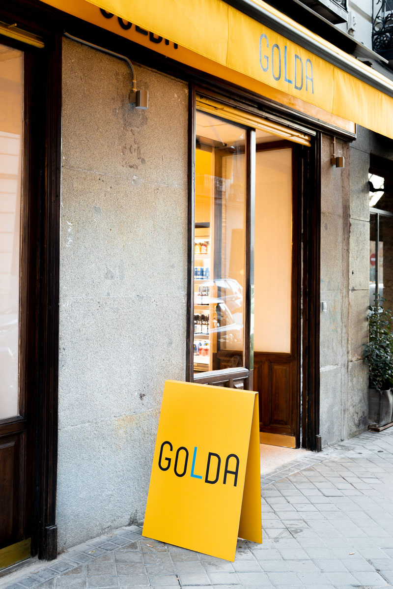 Golda café bar Madrid: entrada del local con carteles en amarillo
