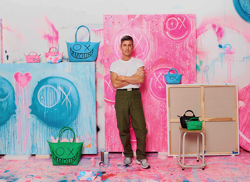 Andre Saraiva, el artista francés posando en su estudio, con bolsos Longchamp