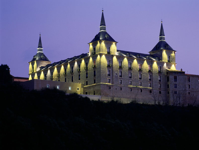 Viajes para conocer la historia y la arquitectura de España: Parador de Lerma encima de una colina. Vista nocturna