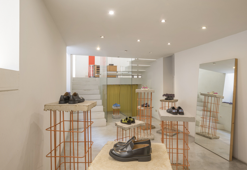 camperlab mallorca 2022: sala mostrando zapatos en primer plano y un espejo en la pared de la derecha