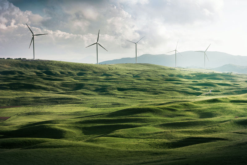 Hidrógeno energía: ventajas e inconvenientes. un campo verde con aerogeneradores