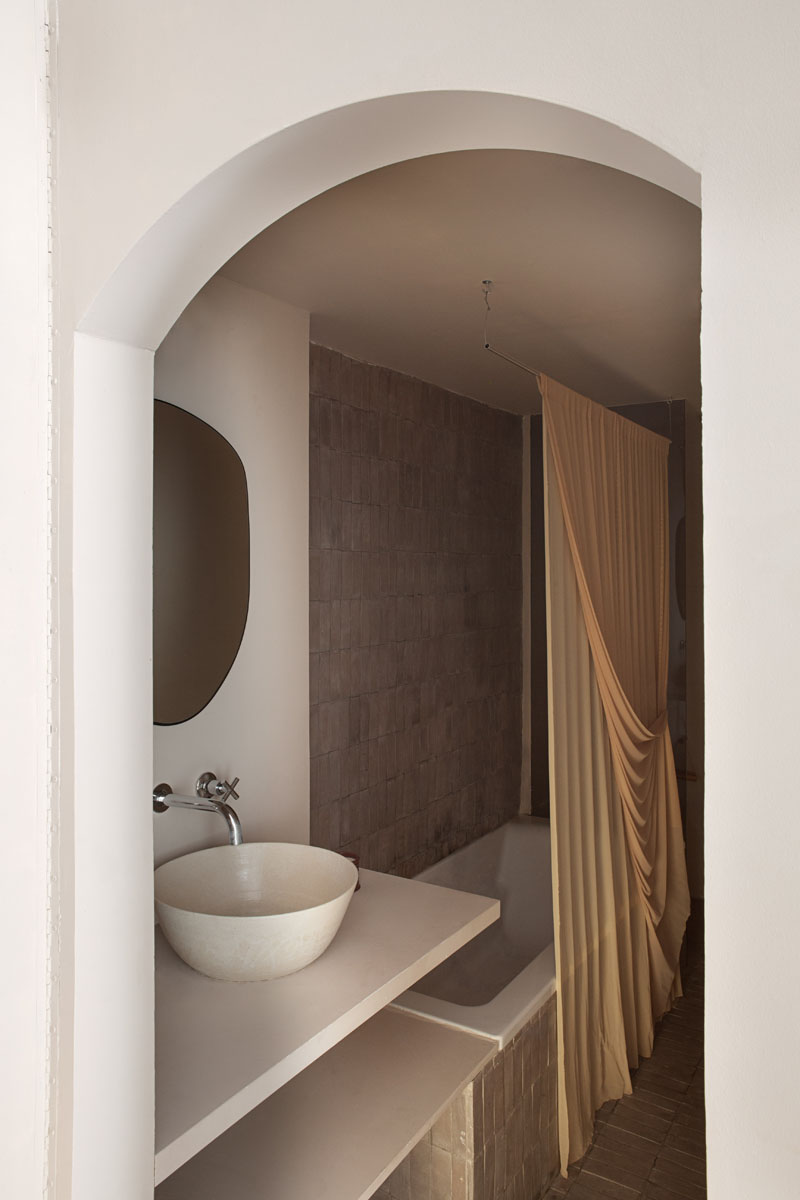 Casa Olivar de Matteo Ferrari y Carlota Gallo: baño interior con puerta de arco