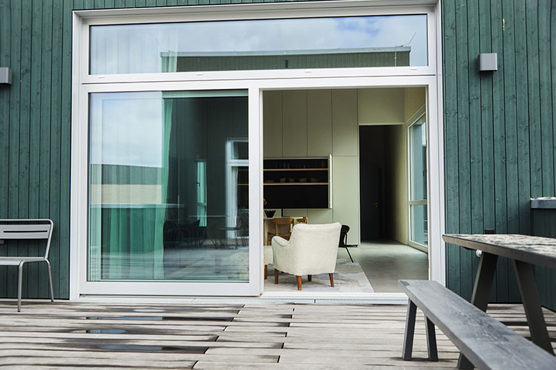 stadtflucht berlin alquiler apartamentos: imagen de una terraza con mesa y banco con acceso a una sala interior
