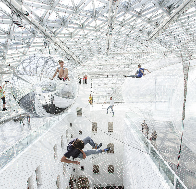 Exposiciones en Dusseldorf - instalación artística aérea con gente flotando sobre redes