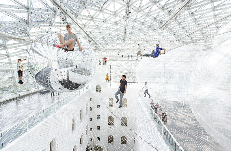 Exposiciones en Dusseldorf - instalación artística aérea con gente flotando sobre redes