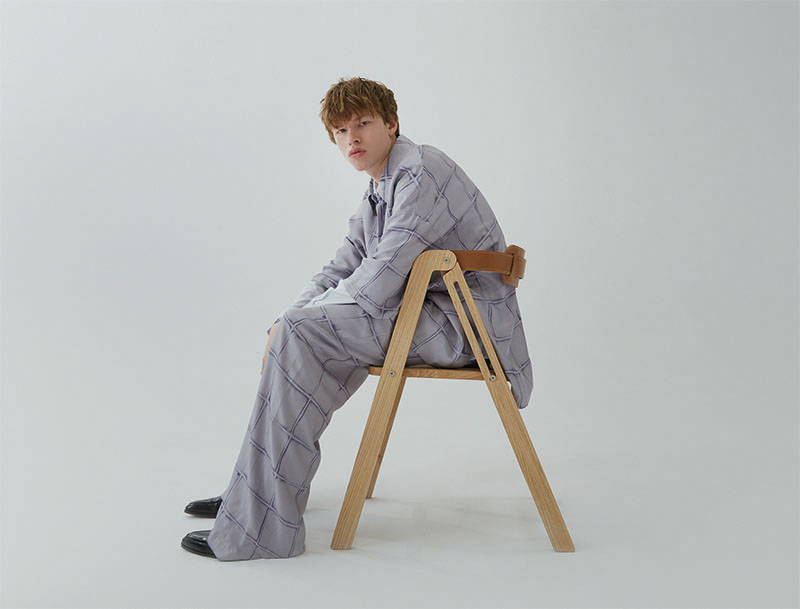 Editorial Flatmates, mezclando Moda y Mobiliario: Paul sentado en una silla plegable de madera