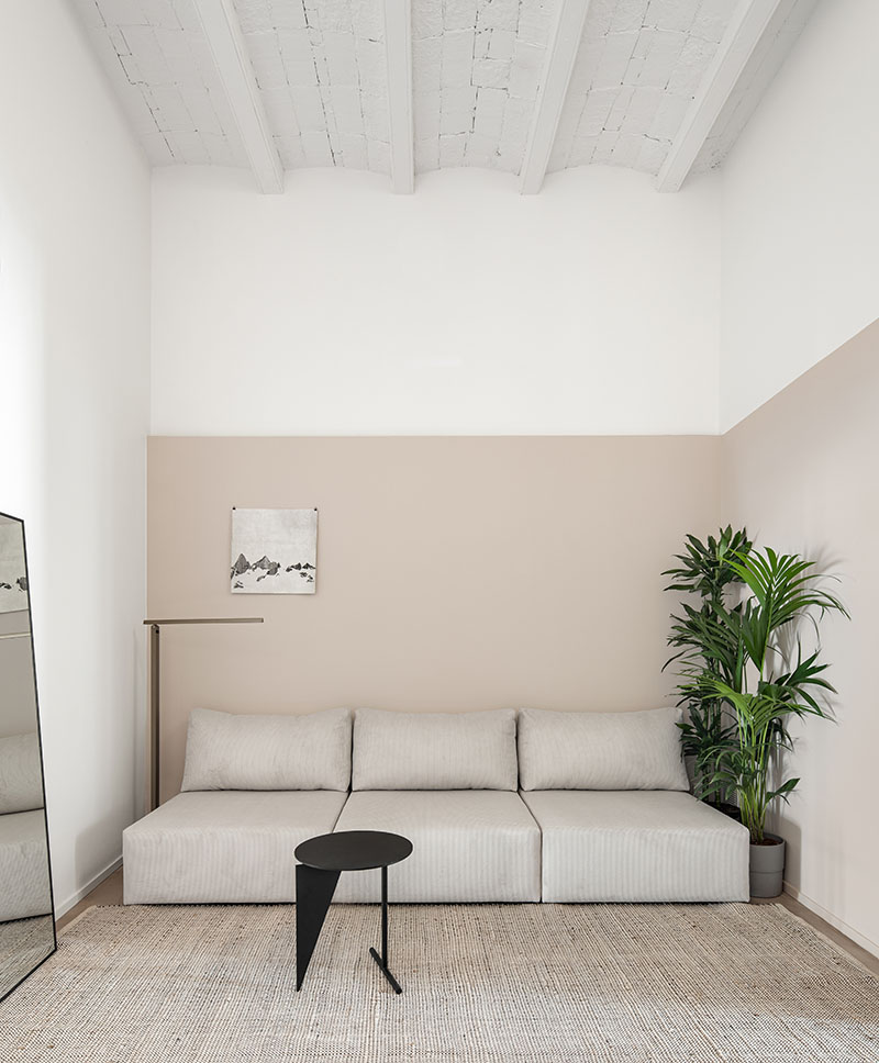 Lama Studio. Reforma de local comercial en un apartamento tipo loft: el salón con un gran sofá