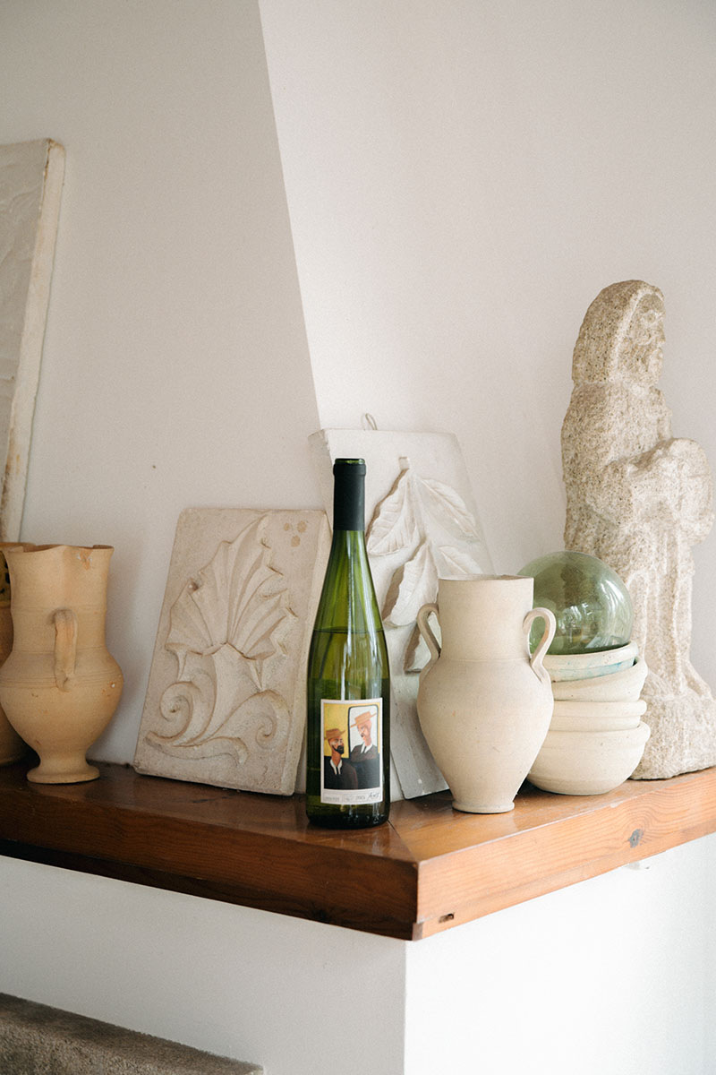 Xandomel vino gallego: la botella encima de una chimenea junto a piezas de cerámica