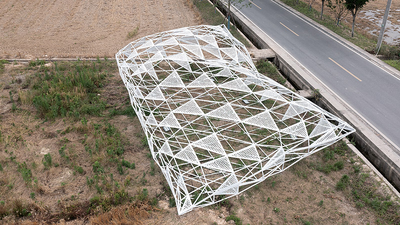 Dream - Penda China - instalación artística de estructura metálica con forma de cojín en un sembrado