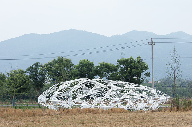 Dream - Penda China - instalación artística de estructura metálica con forma de cojín en un sembrado