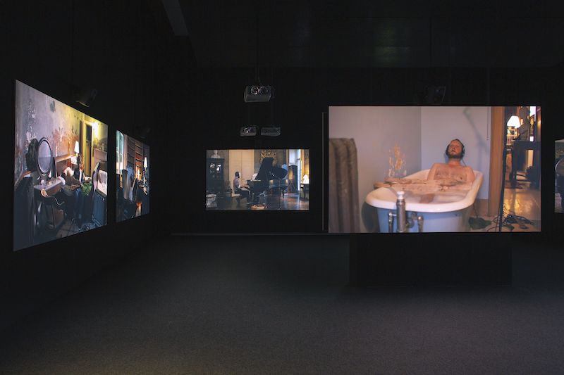"Epic Waste of Love and Understanding", Ragnar Kjartansson, tres pantallas que muestran habitaciones de una casa con gente