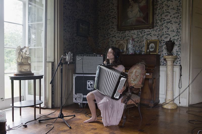 "Epic Waste of Love and Understanding", Ragnar Kjartansson, una mujer tocando el acordeon en un salon antiguo