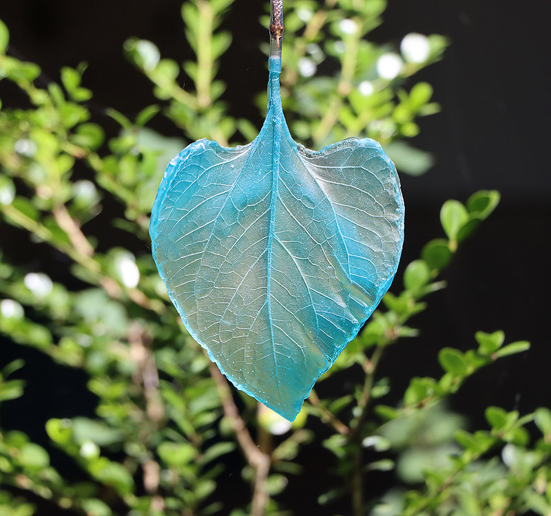 Arte y caos climatico - imagen una hoja de planta con savia azul