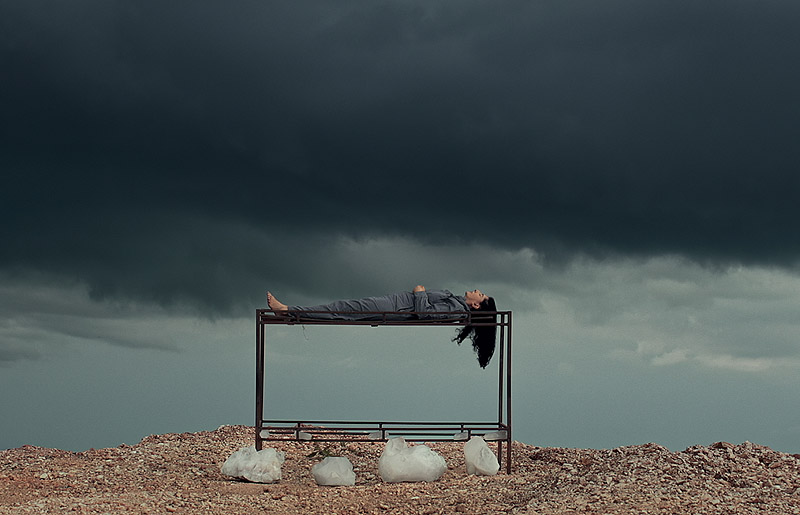 Marina Abramovic - performance de la artista, se la ve tumbada en una cama muy alta en el campo
