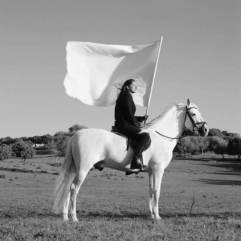 Marina Abramovic - performance de la artista, se la ve sobre un caballo blanco con una bandera blanca