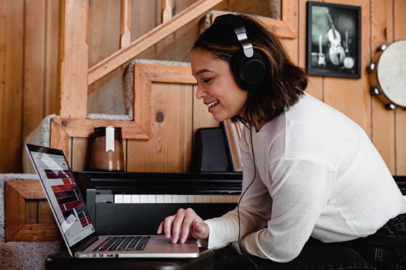 YouTube Music Incubator: Una mujer con cascos mientras usa el ordenador.