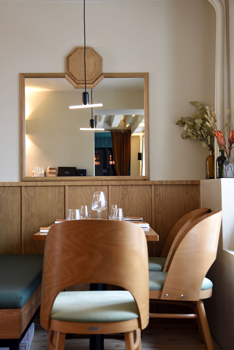 Restaurante Bonhomme París: sillas de madera y un espejo al fondo