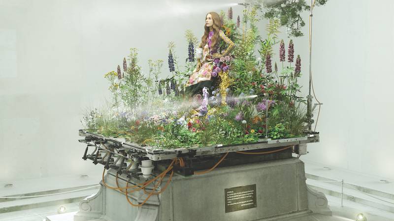 Biennale Némo: un figura de una mujer rodeada de flores y plantas