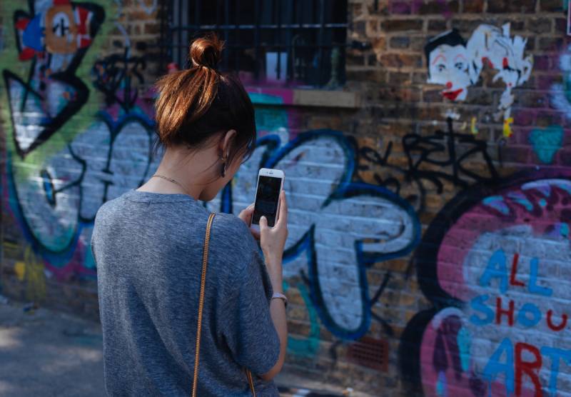 iOS 17: imagen de una mujer sacando una foto con su smartphone.
