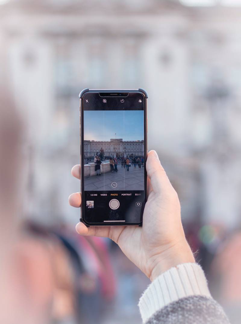 iOS 17: una mujer enfocando para hacer una fotografía con su iPhone.