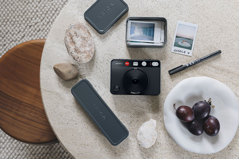 Leica Sofort 2: fotografía de la nueva cámara de Leica de color negro rodeada de otros objetos.