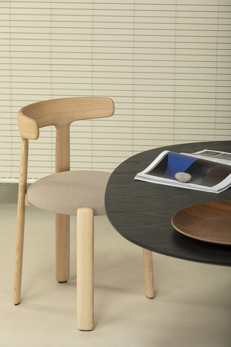 Silla Tura de Manel Molina para Vergés: la silla junto a una mesa negra. Acabado en madera natural