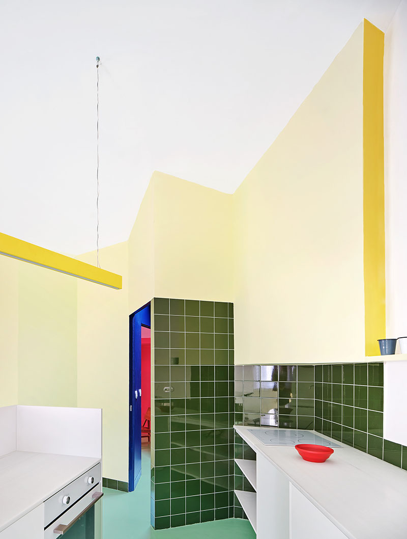 H3o Architects Casa Relámpago: vista de la cocina con muebles de metal y paredes de colores sólidos muy potentes