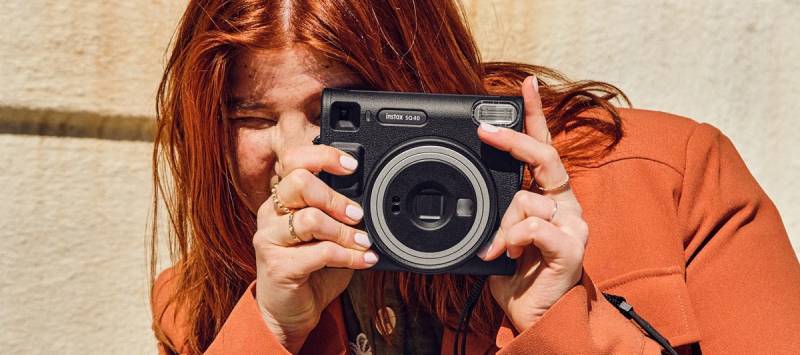 Instax: una mujer posa con una cámara de Fujifilm.