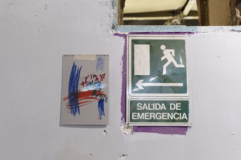 SRGER en Campoamor3 - intervención artística un dibujo de garabatos junto a una señal de salida de emergencia