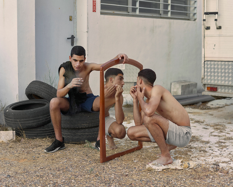 Dialect.Felipe Romero Beltrán. Dos chicos en una imagen, uno sujeta un espejo grande mientras el otro se afeite.