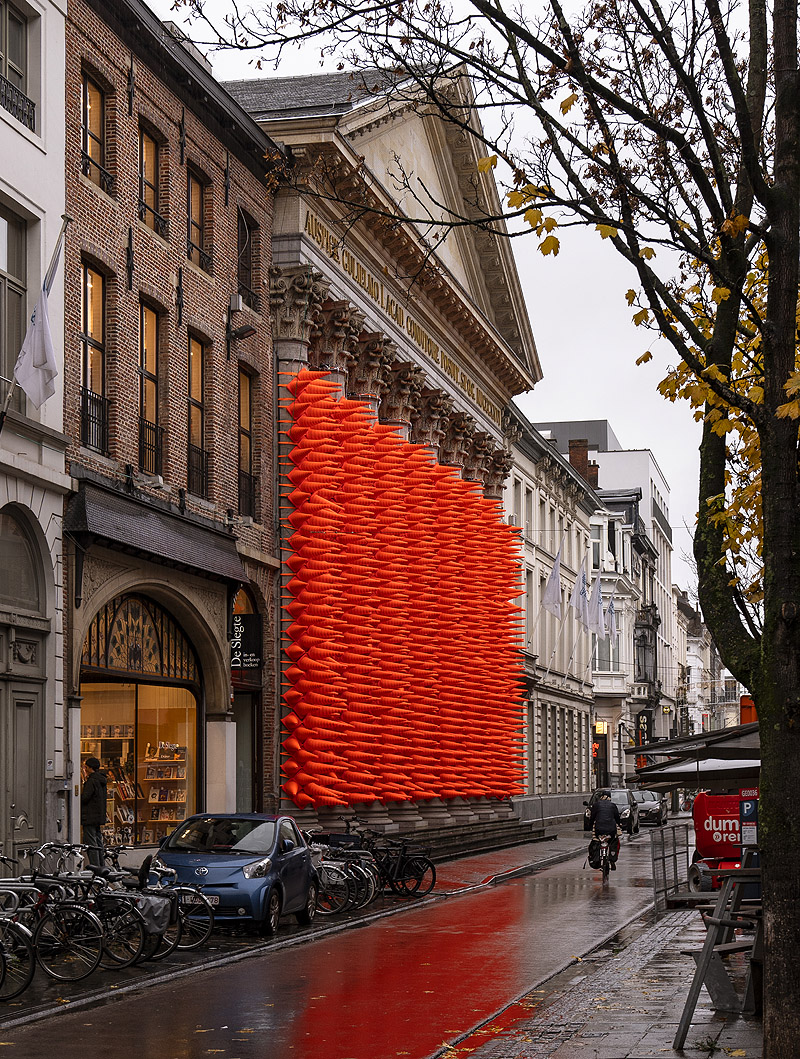 Vista de la instalación "Cones" cientos de conos de tráfico naranjas, forran las columnas del frontal de la universidad de Gante